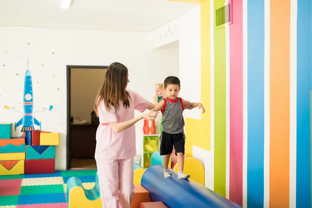 Come allestire una stanza psicomotricità efficace - bambino che cammina su un ostacolo