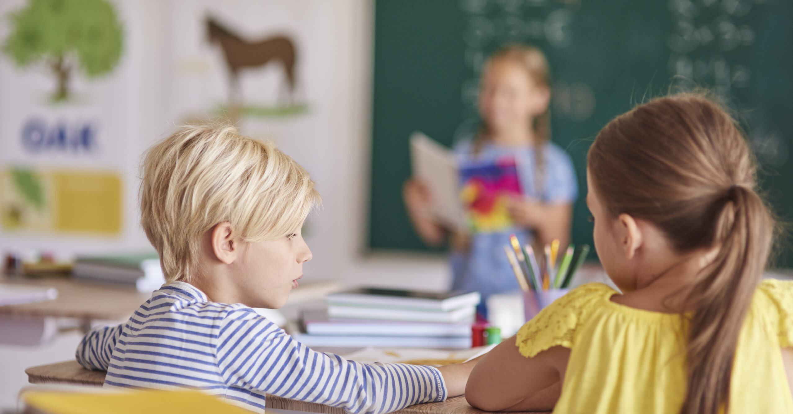 Bambini ripresi di spalle durante un’attività didattica in classe